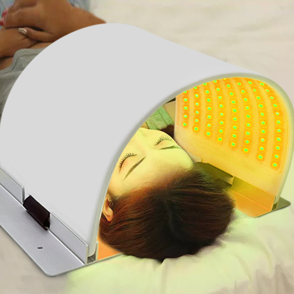 LMPH240 person using the LED photon light therapy mask with green/yellow light setting active